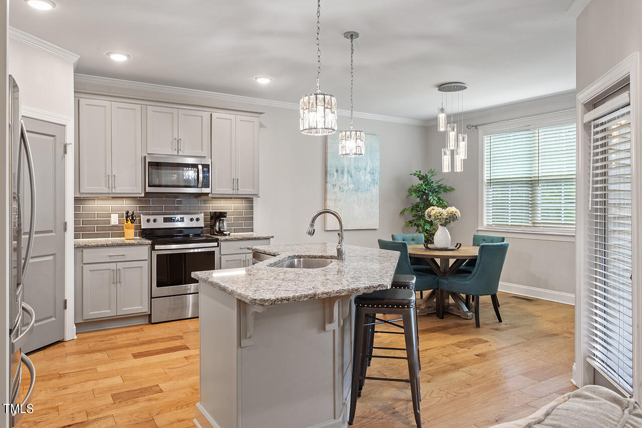 3925 Billy Hopkins Road Zebulon, NC 27597 - Photo 8 of 40 a kitchen with microwave a stove a table and chairs in it