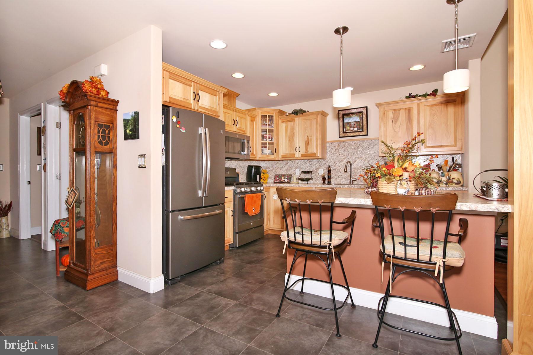 1122 Alden Way Lebanon, PA 17042 - Photo 6 of 66 a kitchen with stainless steel appliances kitchen island granite countertop a dining table chairs and a refrigerator