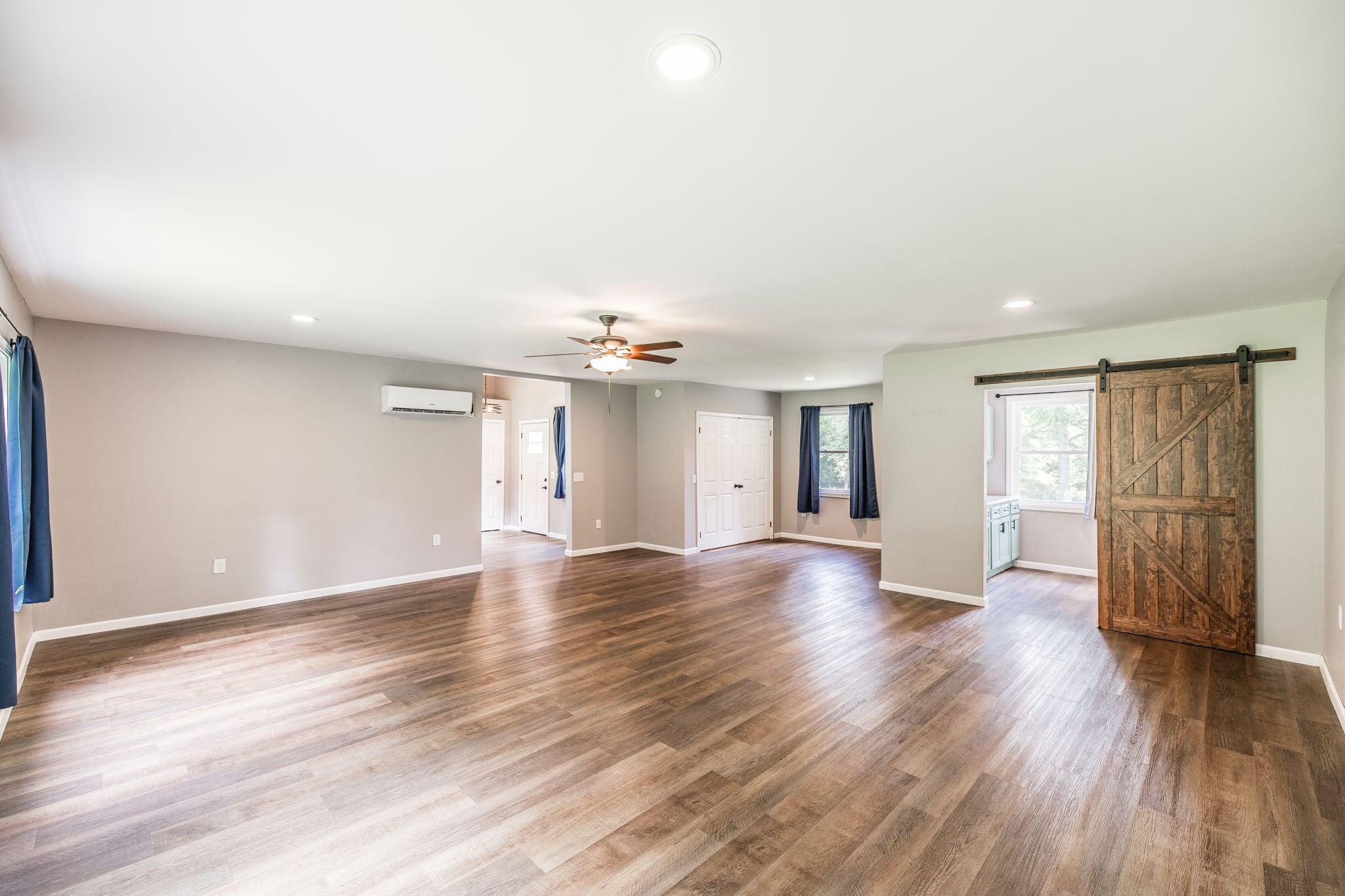 13989 Owens Chapel Road Springfield, TN 37172 - Photo 17 of 43 an empty room with wooden floor chandelier fan and windows