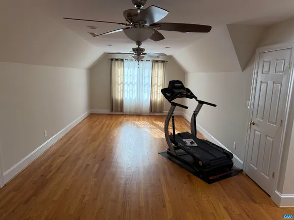 a room with gym equipment and wooden floor