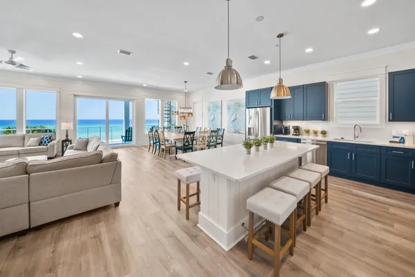 a living room with stainless steel appliances kitchen island granite countertop a sink a stove a dining table and chairs