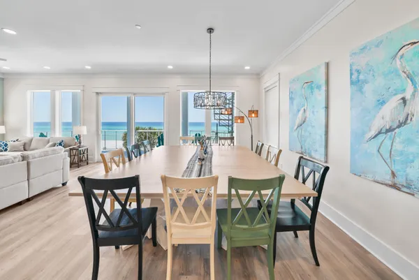 a dining room with furniture a chandelier and wooden floor
