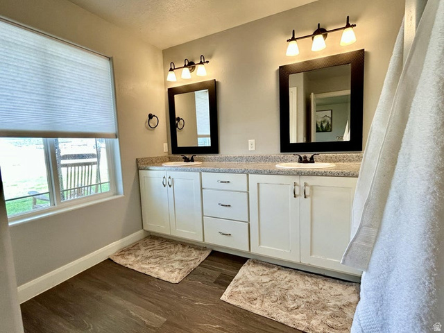 310 625 East Enterprise, UT 84725 - Photo 21 of 36 Dual vanity with white cabinetry and chrome hardware, speckled countertop, and wood-finish flooring