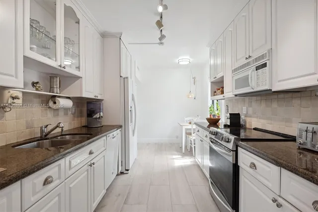 a bathroom with a toilet a sink a glass door a shower a mirror and vanity
