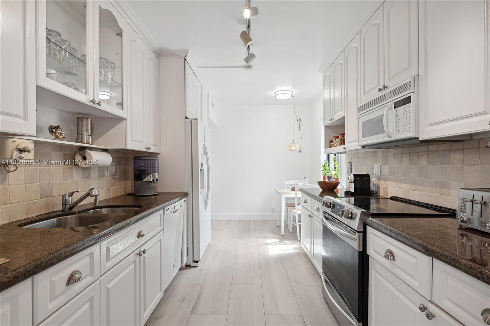 161 Crandon Boulevard, Unit 412 Key Biscayne, FL 33149 - Photo 12 of 15 a kitchen with stainless steel appliances granite countertop a sink stove and cabinets