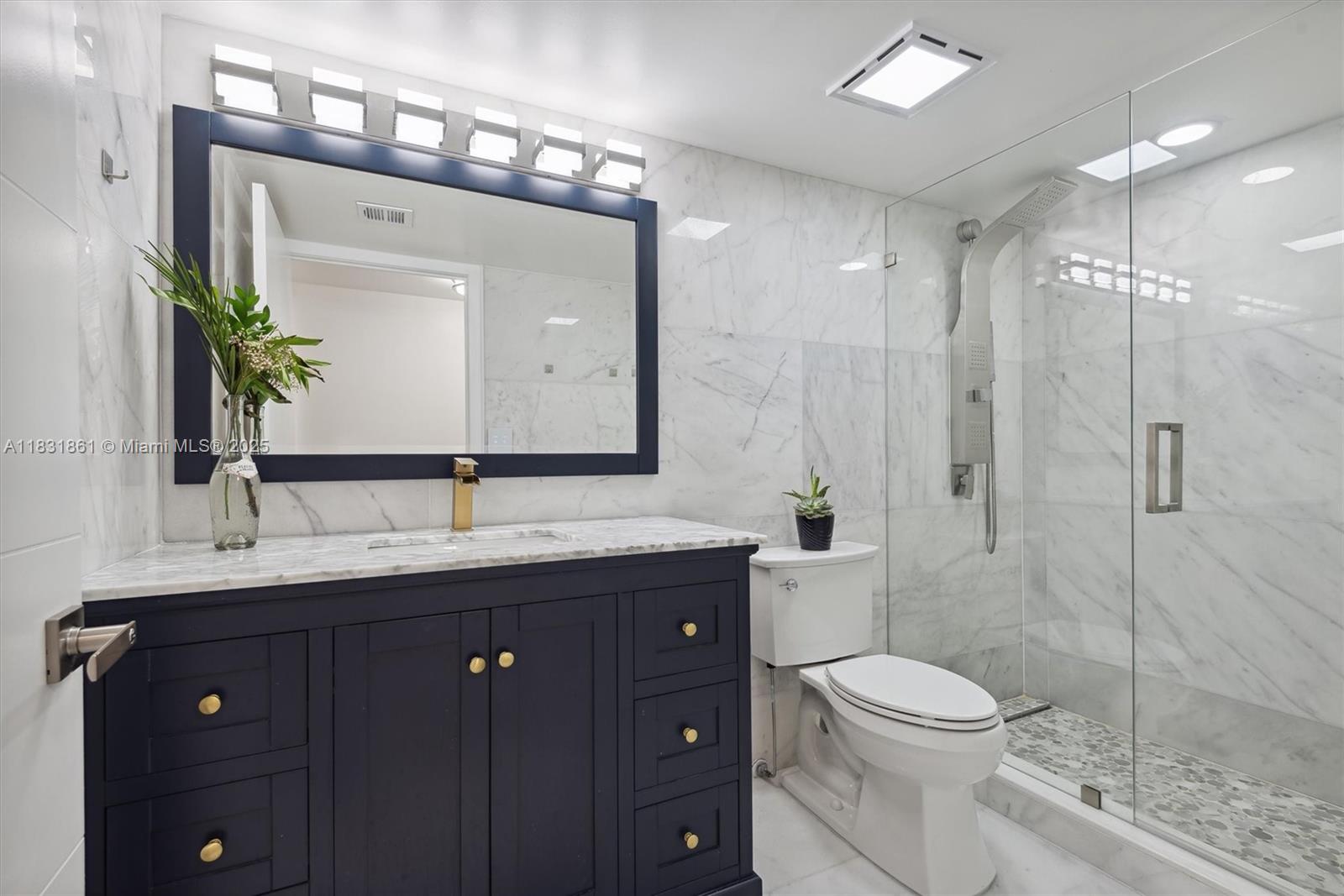 161 Crandon Boulevard, Unit 412 Key Biscayne, FL 33149 - Photo 13 of 15 a bathroom with a toilet a sink a glass door a shower a mirror and vanity