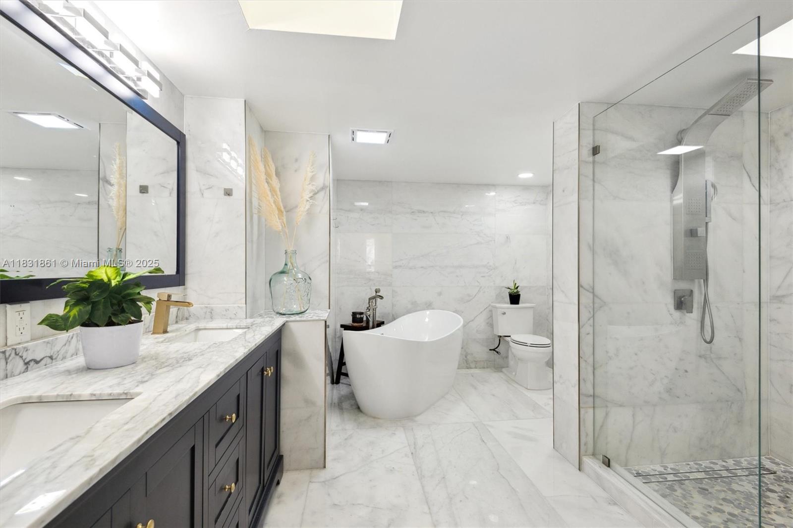 161 Crandon Boulevard, Unit 412 Key Biscayne, FL 33149 - Photo 7 of 15 a bathroom with a granite countertop sink a toilet a mirror and shower