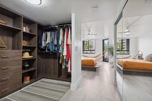 a view of a hallway to room with wooden floor and furniture