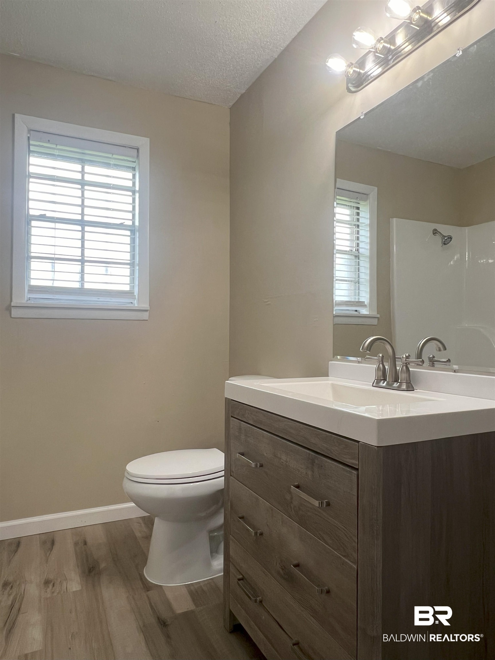 508 Freemanville Drive Atmore, AL 36502 - Photo 20 of 27 Bathroom featuring vanity, a textured ceiling, hardwood / wood-style flooring, and toilet