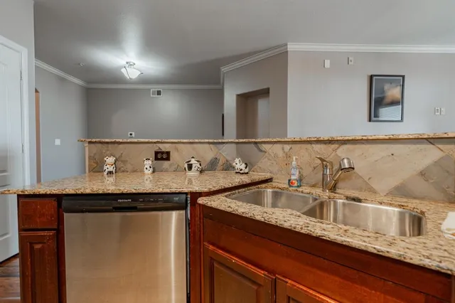 a kitchen with granite countertop stainless steel appliances a sink and a counter top