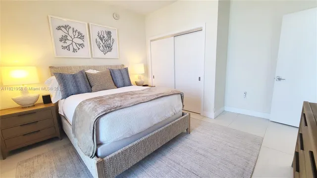 a spacious bedroom with a bed and painting on the wall