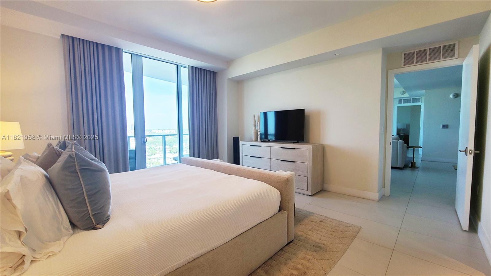 3100 North Ocean Drive, Unit 1206 Singer Island, FL 33404 - Photo 16 of 40 a bedroom with a bed and a television