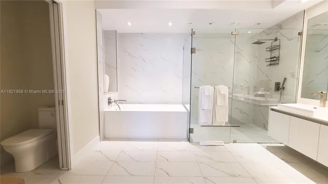 a bathroom with a tub a toilet and a shower