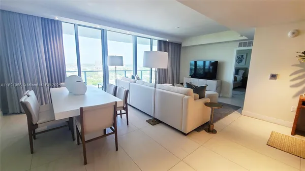 a living room with furniture and large windows
