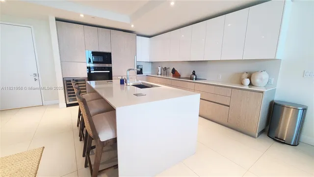 a kitchen with a sink a stove and white cabinets