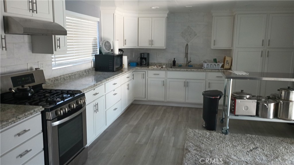 17800 Langlois Road Desert Hot Springs, CA 92241 - Photo 18 of 19 a kitchen with granite countertop a sink stove and cabinets
