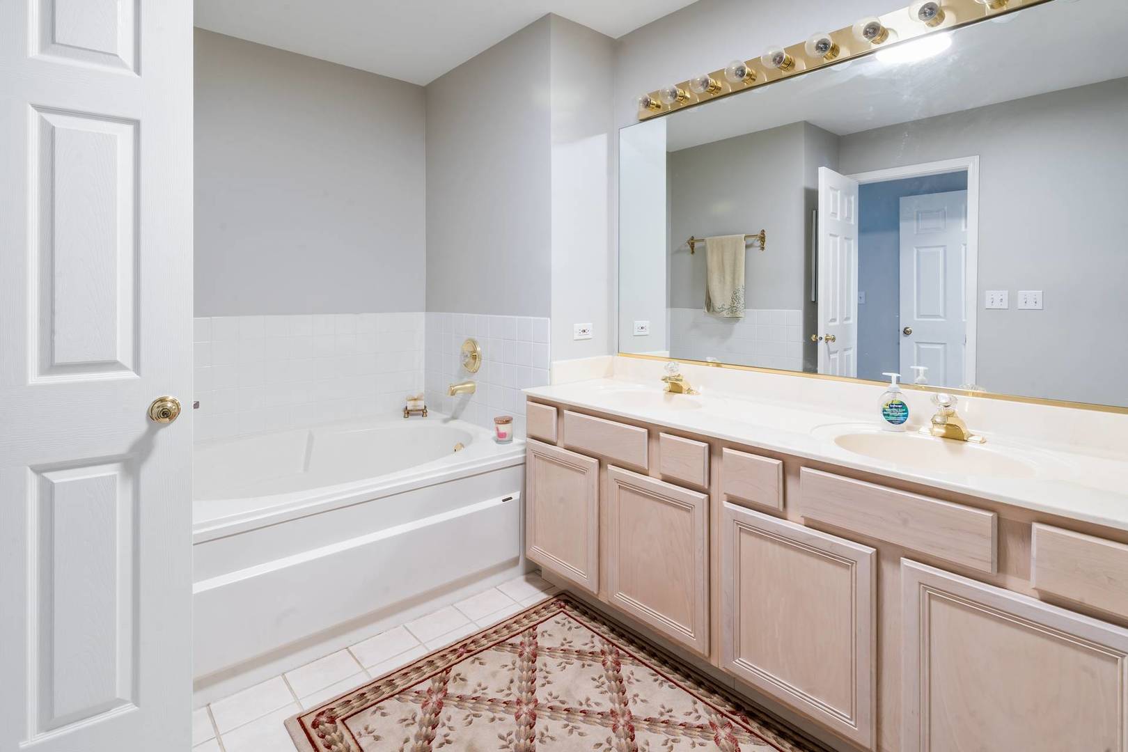 232 Manor Drive Buffalo Grove, IL 60089 - Photo 14 of 21 a bathroom with a tub sink and a mirror