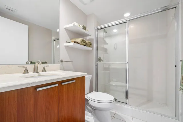 a bathroom with a granite countertop sink toilet and shower
