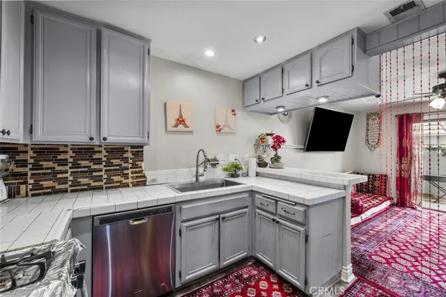 a kitchen with stainless steel appliances granite countertop a refrigerator and a potted plant