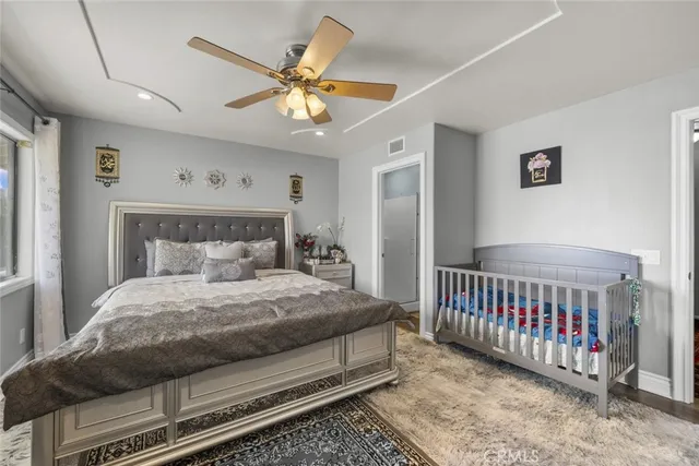 a bedroom with a bed and a large mirror with a chandelier