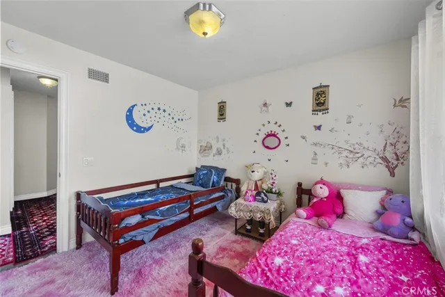 a bedroom with a bed a potted plant and a window