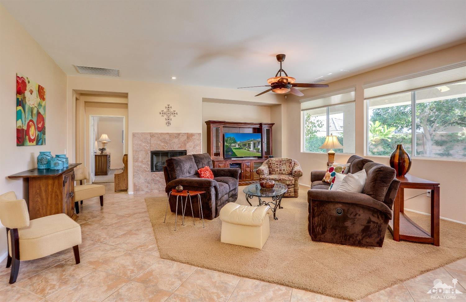 83313 Lone Star Road Indio, CA 92203 - Photo 7 of 23 a living room with furniture a fireplace and a chandelier