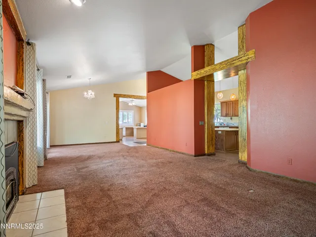 a view of an empty room with window and fire place
