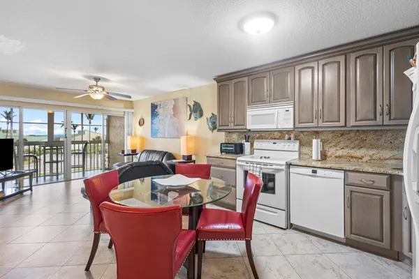 a kitchen with a dining table chairs and white cabinets