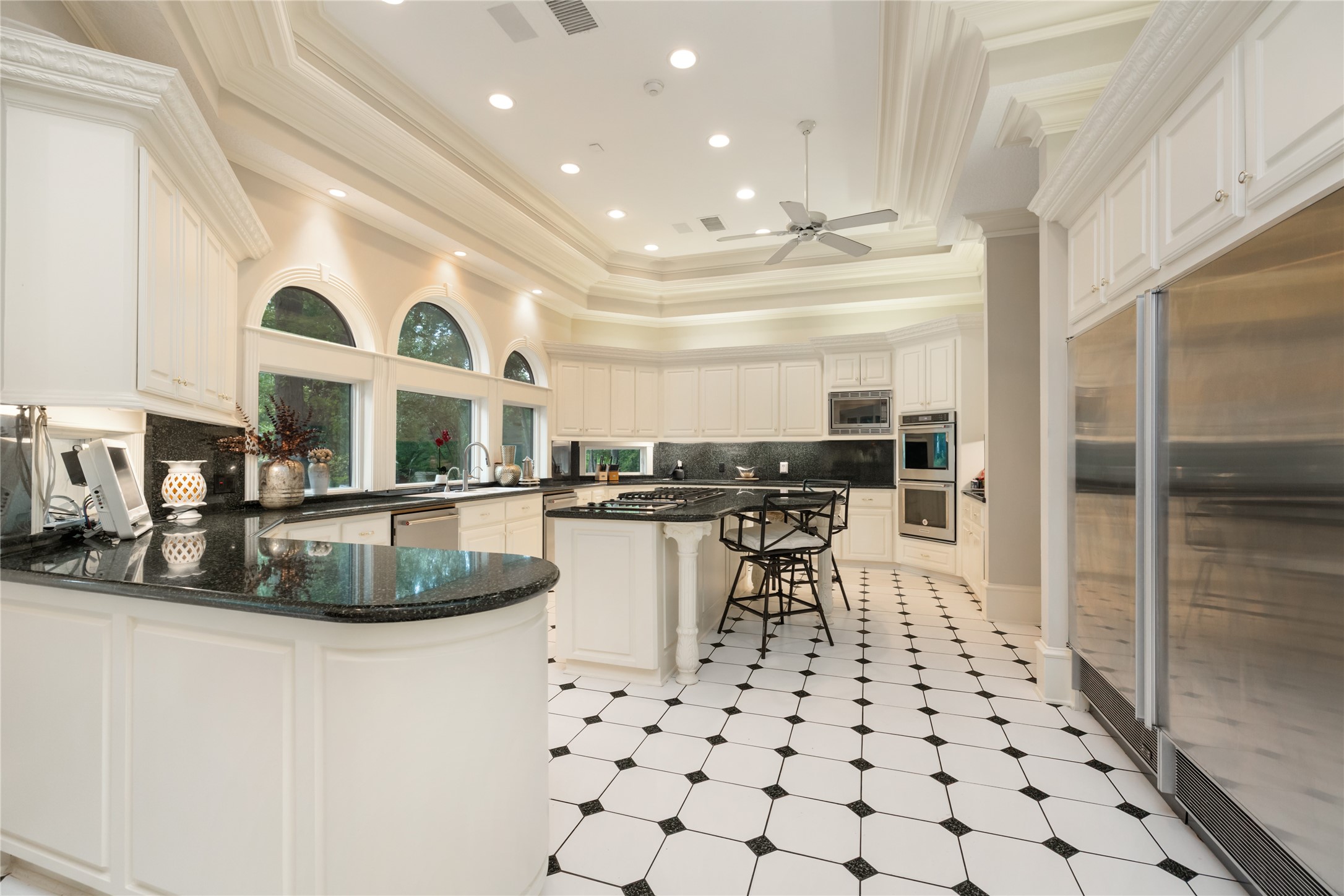 205 Grogans Point Road The Woodlands, TX 77380 - Photo 30 of 49 a kitchen with stainless steel appliances kitchen island granite countertop a sink and cabinets