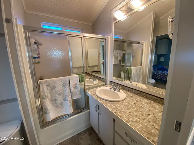 a bathroom with a granite countertop sink mirror vanity and shower