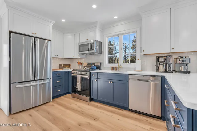 a kitchen with stainless steel appliances granite countertop a refrigerator stove and sink