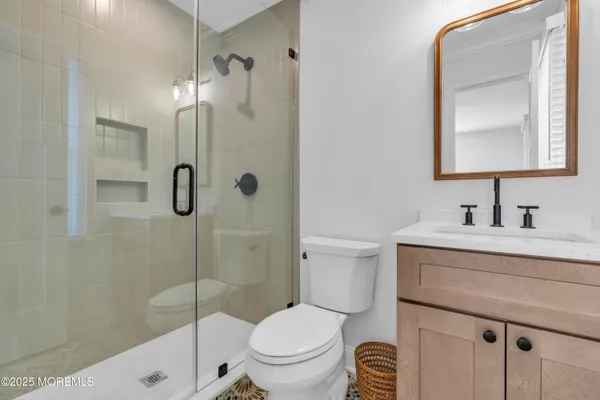 a bathroom with a sink a toilet and shower