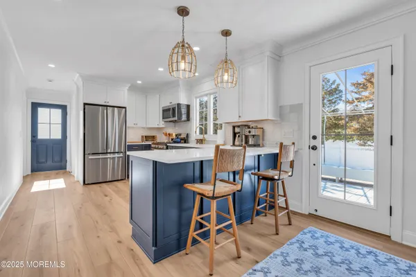 a kitchen with granite countertop wooden floor and stainless steel appliances
