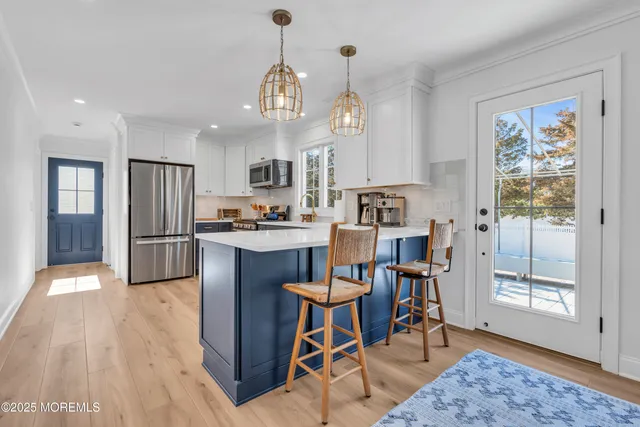 a kitchen with granite countertop wooden floor and stainless steel appliances
