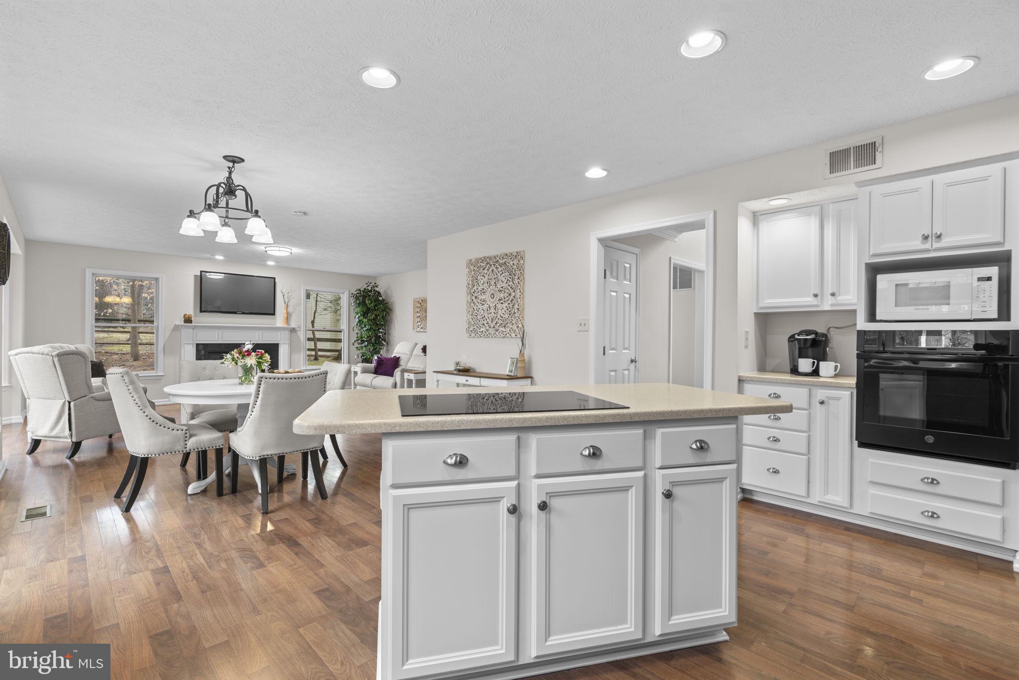 6241 Martin Road Columbia, MD 21044 - Photo 13 of 53 a large white kitchen with lots of counter space dining table and stainless steel appliances