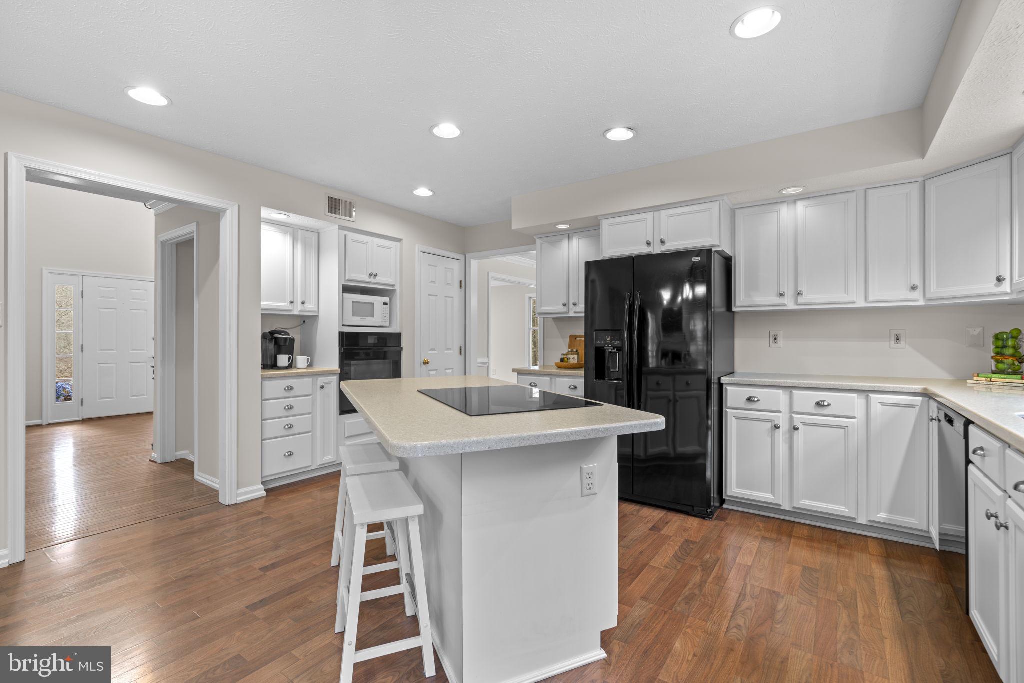6241 Martin Road Columbia, MD 21044 - Photo 14 of 53 a kitchen with stainless steel appliances a sink a stove a refrigerator cabinets and wooden floor