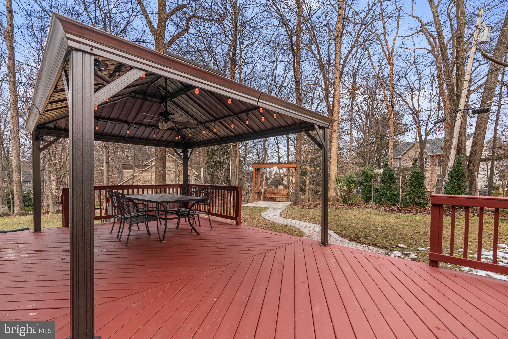 6241 Martin Road Columbia, MD 21044 - Photo 50 of 53 a view of a roof deck with table and chairs a barbeque with wooden floor and fence