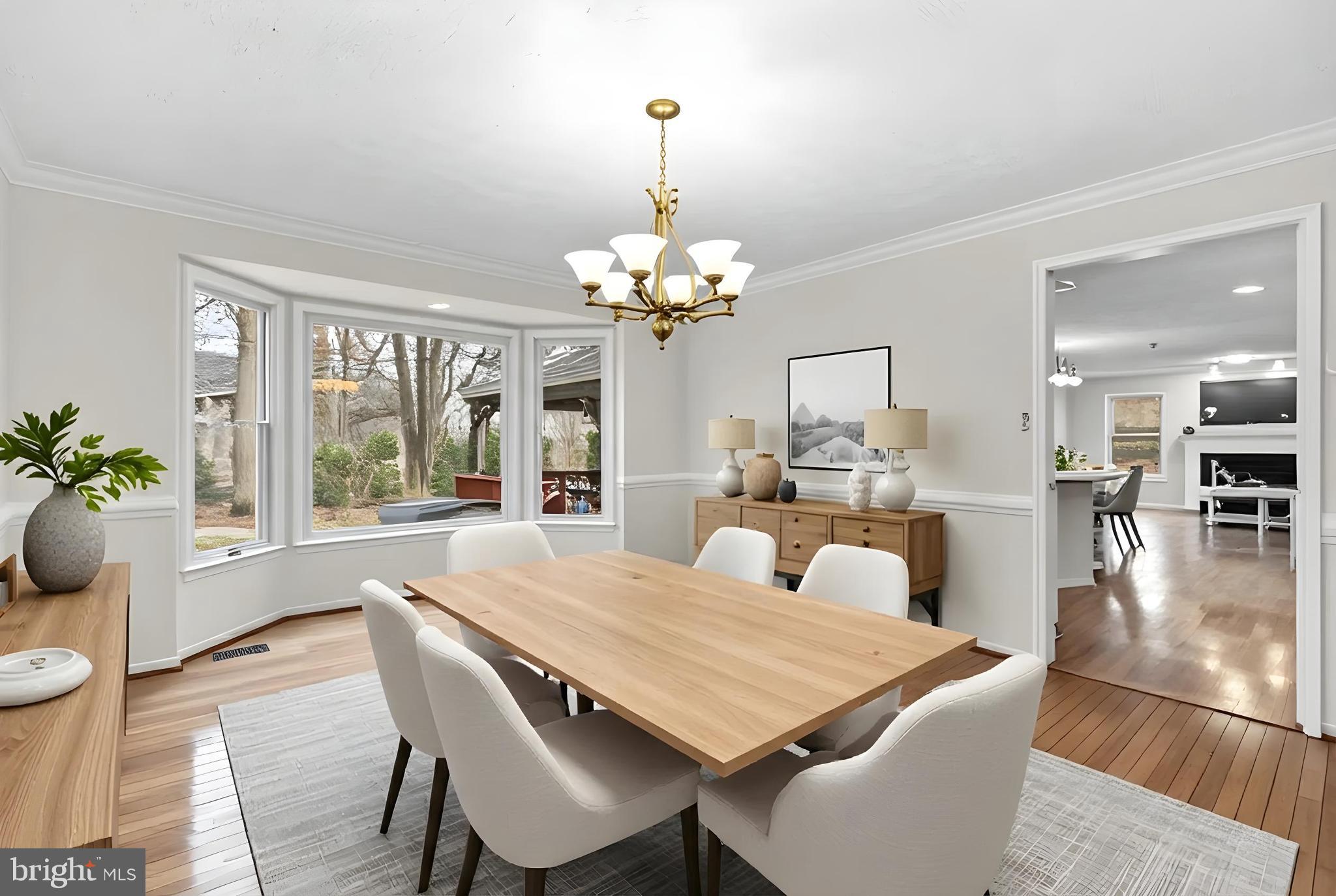 6241 Martin Road Columbia, MD 21044 - Photo 8 of 53 a dining room with wooden floor a chandelier a wooden table and chairs