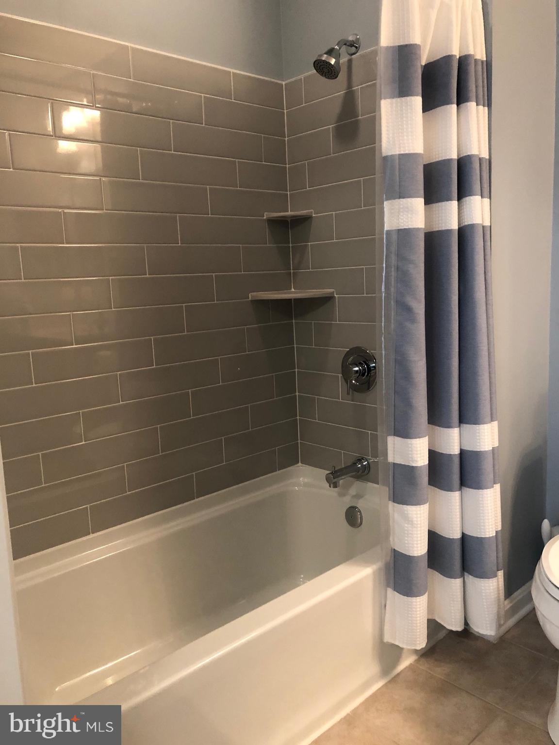 400 Symphony Circle, Unit 354D Cockeysville, MD 21030 - Photo 18 of 33 a bathroom with a bathtub and a shower