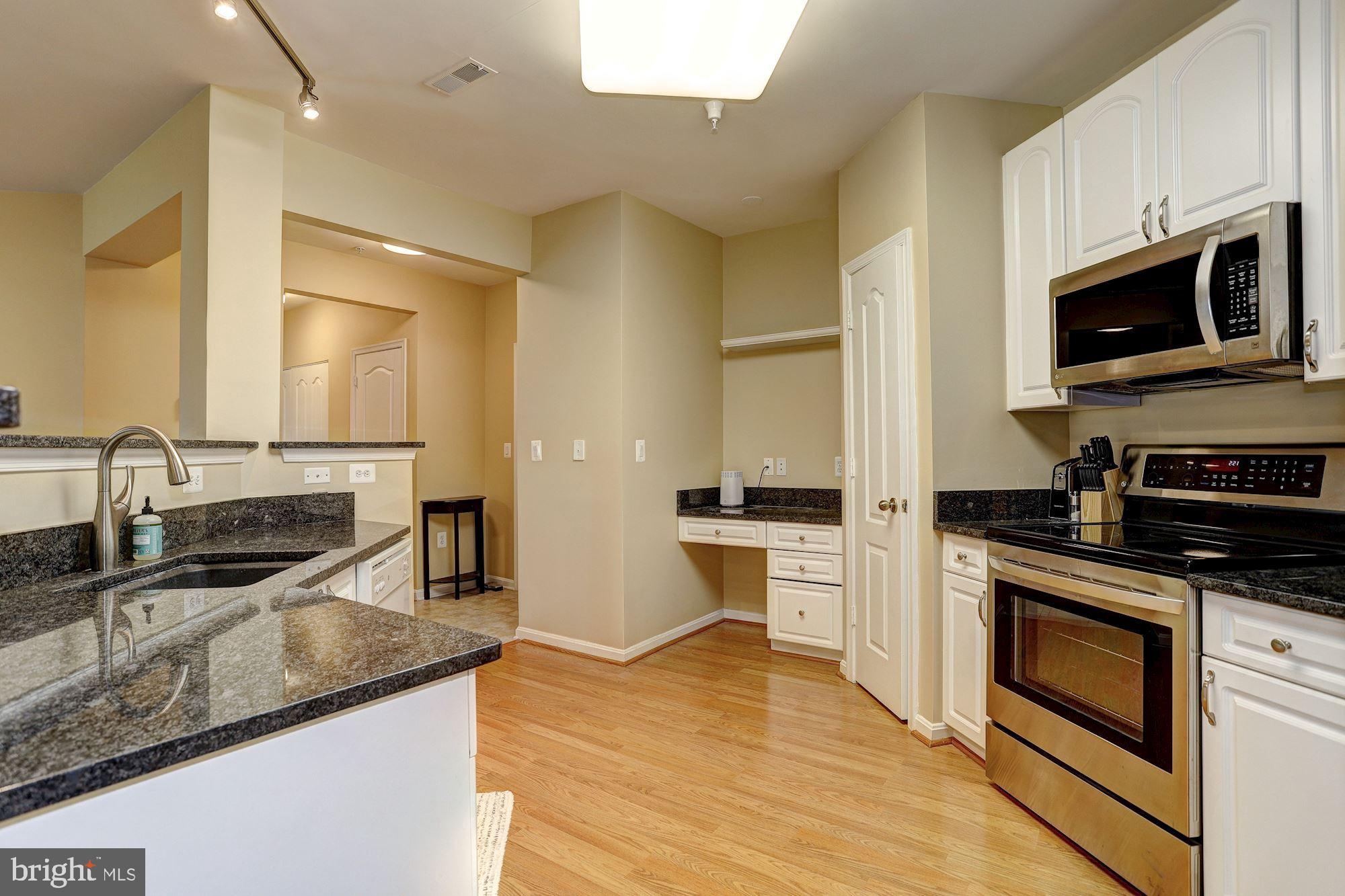 400 Symphony Circle, Unit 354D Cockeysville, MD 21030 - Photo 7 of 33 a kitchen with stainless steel appliances granite countertop a sink and a stove top oven with wooden floor