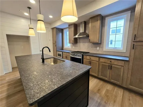 a kitchen with kitchen island a counter space a sink appliances and cabinets