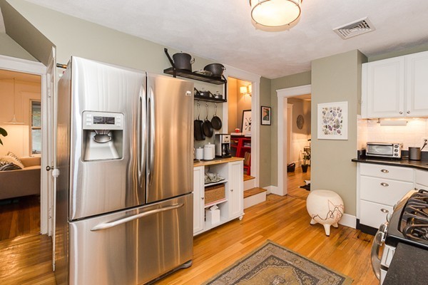 52 Aberdeen Road Arlington, MA 02476 - Photo 14 of 30 a kitchen with stainless steel appliances a refrigerator a stove a microwave and a dining table with wooden floor
