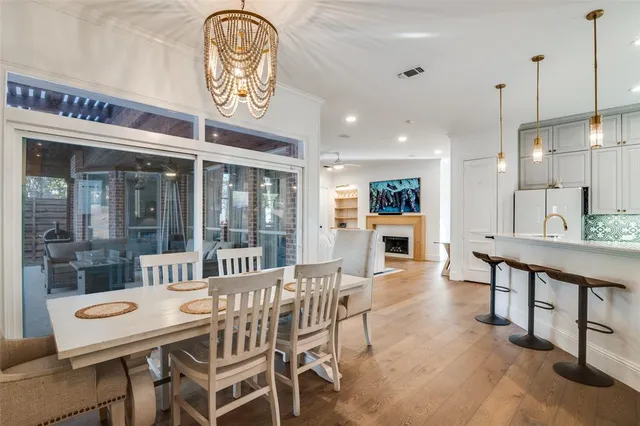 a dining room with furniture a floor to ceiling window and a kitchen view