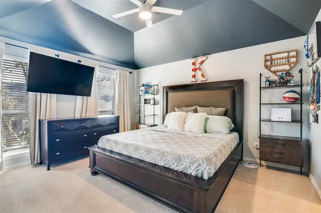 a bedroom with a large bed and a flat tv screen on dresser