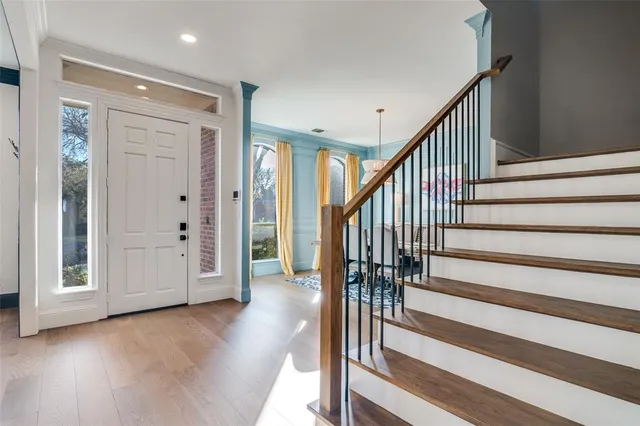 a view of a hallway with wooden floor and staircase