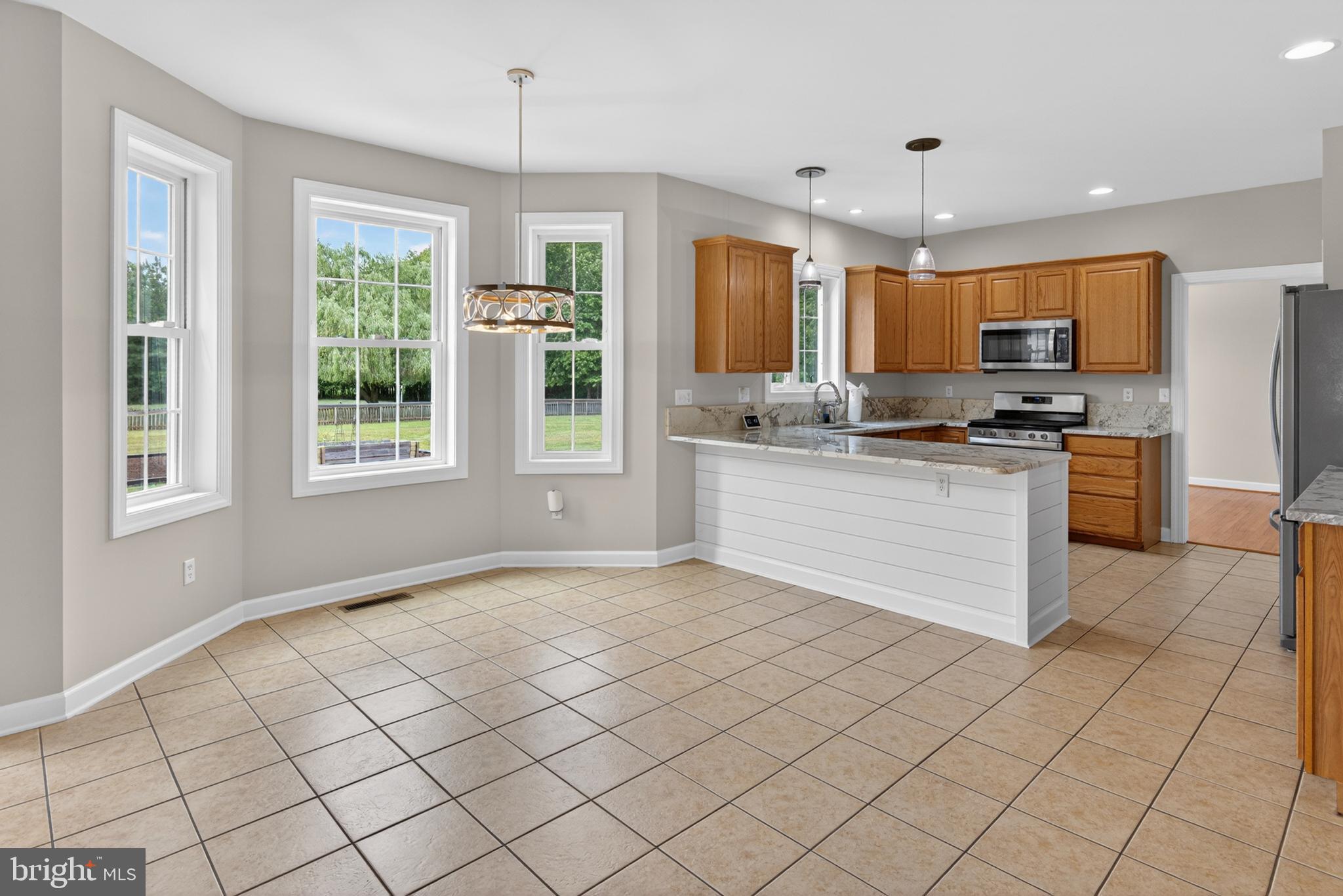 337 Roe Ingleside Road Centreville, MD 21617 - Photo 25 of 56 a kitchen with stainless steel appliances granite countertop a stove top oven a sink a counter top space cabinets and a window