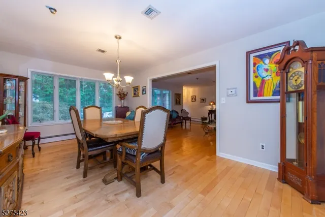a dining room with furniture a chandelier and wooden floor