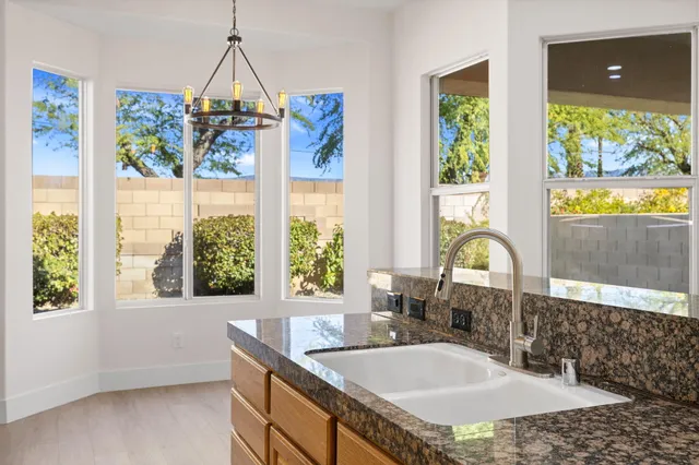 a bathroom with a granite countertop sink and a window