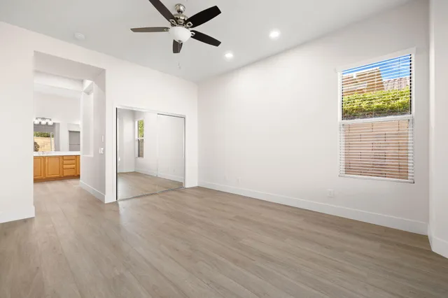 a view of a livingroom with wooden floor and a ceiling fan