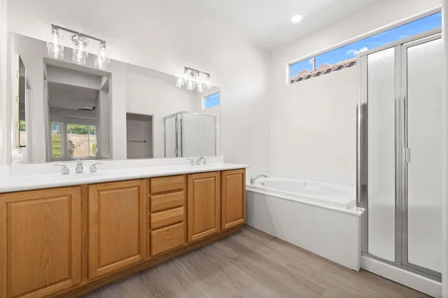 a spacious bathroom with a double vanity sink a mirror and a bathtub
